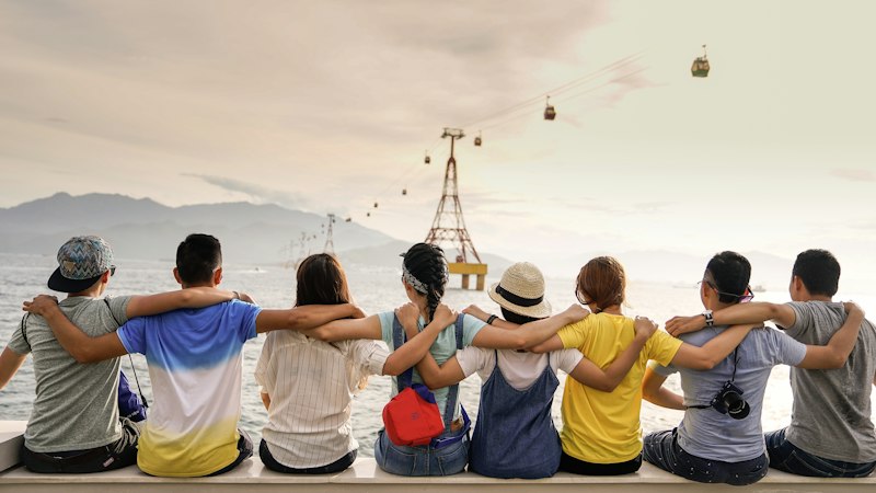 Group of friends embracing and enjoying a scenic shared trip view